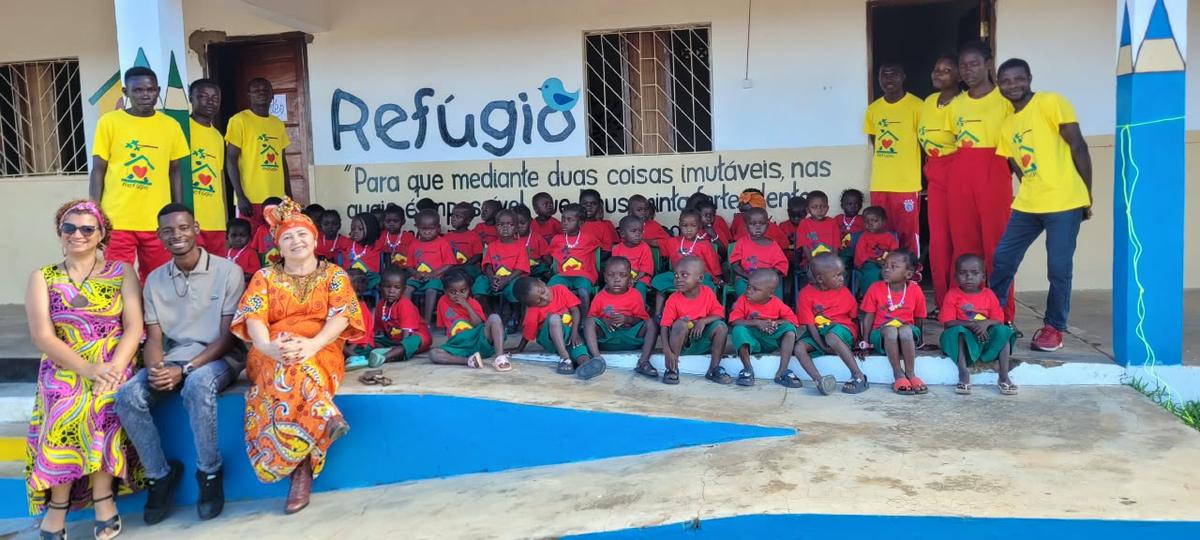 Crianças e equipe diante da Escola Refúgio, em Moçambique